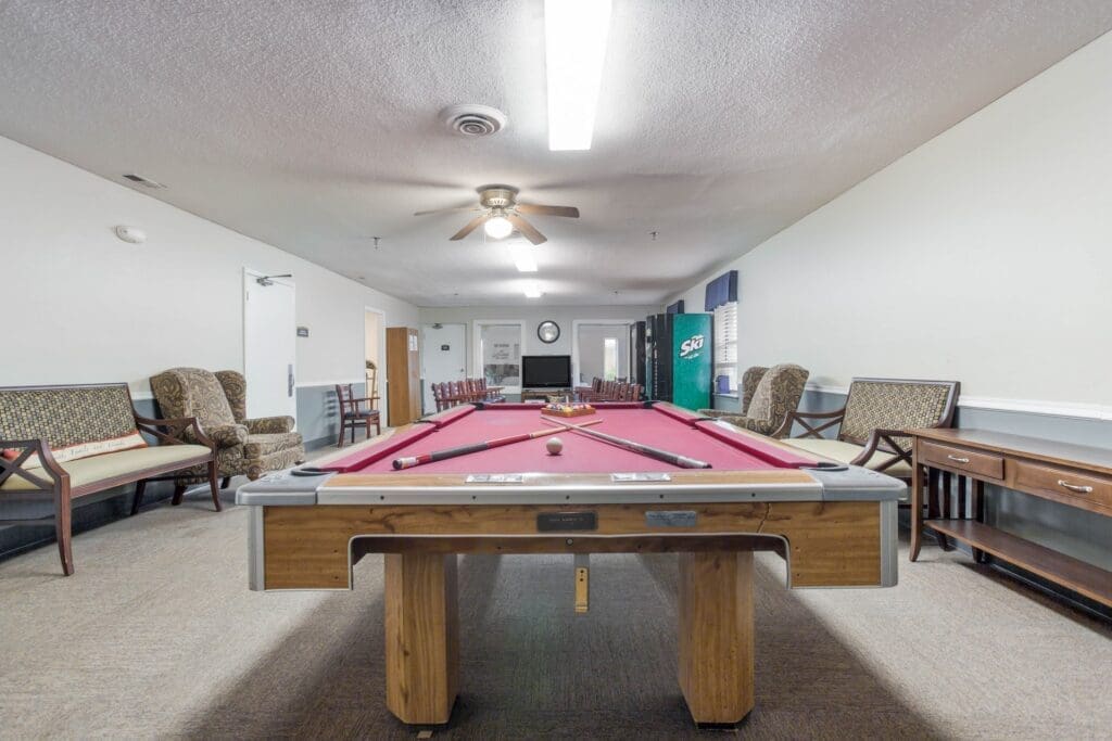 Game room featuring pool table and numerous armchairs, benches, and vending machines